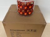 une boîte remplie de décorations de Noël posée par terre