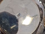 a close up of a silver tea pot with a clock on it