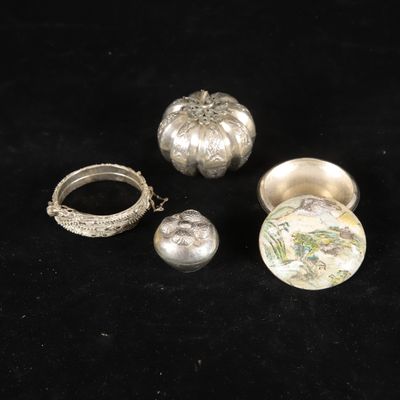 a group of silver objects on a black surface with a black background