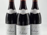 trois bouteilles de vin rouge posées sur une table blanche