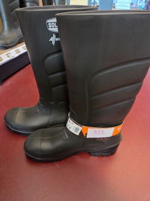 pair of black rubber boots sitting on top of a red table
