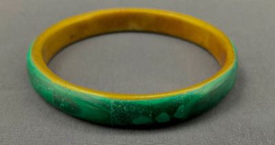 un gros plan d'un bracelet vert et jaune posé sur une table