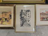 three framed pictures of buildings and a staircase are on a wall