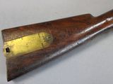 an old wooden rifle with a brass plate on the side of it