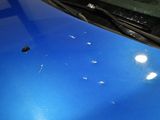 a blue car with bullet holes on the hood of it