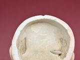 a white vase with a face on it sitting on a table