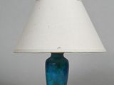 a blue lamp with a white shade on a table