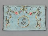 an embroidered purse with a bird and flowers hanging from it ' s side