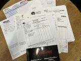 beaucoup de papiers posés sur une table sur laquelle se trouve un livre