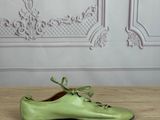 pair of green shoes sitting on a wooden table in front of a wall