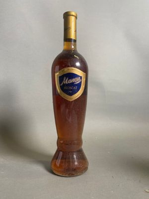 une bouteille d'alcool posée sur une table à côté d'un verre de vin