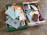 une boîte verte remplie de livres et de papiers posée sur un plancher en bois