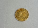 an image of a gold coin sitting on top of a white surface