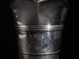 a silver vase that is sitting on a table