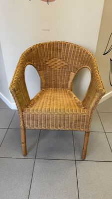 une chaise en osier dans un coin de la pièce