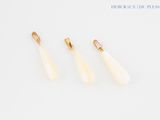 three pairs of gold and white earrings on a white surface