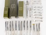 beaucoup de couverts sur une table, à côté d'une boîte à couverts