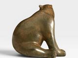 an image of a bronze sculpture of a cat sitting on its back