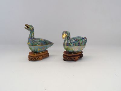 pair of ceramic ducks on wooden stands on a white surface