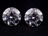 une paire de diamants ronds taille brillant sur un fond noir