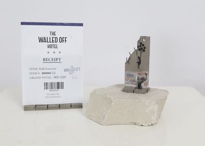a statue of a man on a rock next to a hotel ticket