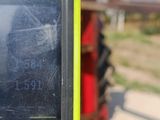 une personne tenant un téléphone portable devant un tracteur