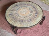 une table ronde dont le plateau est orné d'une mosaïque