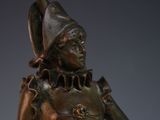 bronze statue of a woman holding a watering can with a hat on top of her head