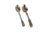 two spoons that are sitting next to each other on a table