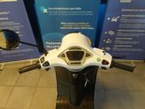 a motor scooter that is parked in front of a sign