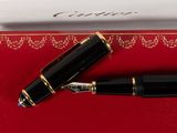 a black pen sitting on top of a red box