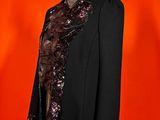 an image of a black jacket on a mannequin with a red background
