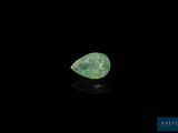 a close up of a green diamond on a black surface