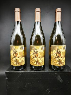 trois bouteilles de vin posées sur un bloc de bois