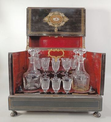 des bouteilles et des verres dans un coffret posé sur un présentoir muni d'une horloge