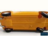 a yellow toy truck with wheels on a white surface