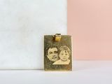 un pendentif plaqué or sur lequel figure la photo de deux personnes
