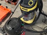un aspirateur jaune et noir posé par terre à côté d'autres outils
