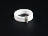 un gros plan d'une bague blanche sertie d'un diamant