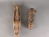deux masques en bois sculptés sur un fond gris