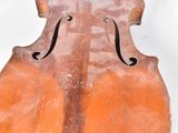 an old violin sitting on top of a white surface
