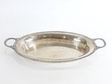 un plateau en argent muni de poignées, sur fond blanc
