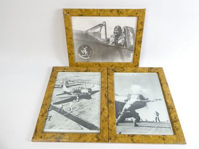 trois photos encadrées d'avions anciens exposées sur une surface blanche