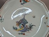 a white plate with a picture of a woman and a bird on it