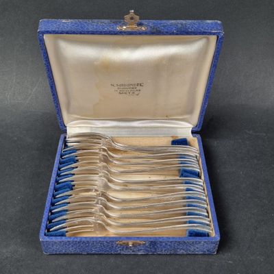 silverware in a blue case with blue handles on a black surface