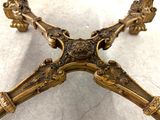 a gold colored table with ornate carvings on it