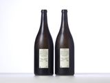 two bottles of wine sitting on top of a table next to each other