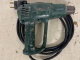 a green cord attached to a cord with a drill