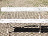 un banc blanc posé sur un trottoir pavé