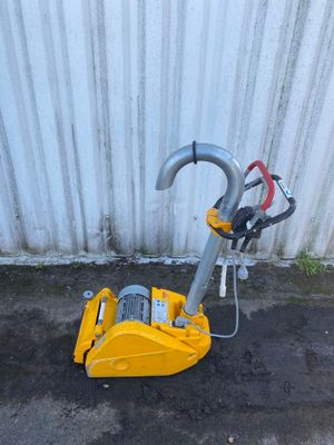 une machine posée sur le sol à côté d'un bâtiment